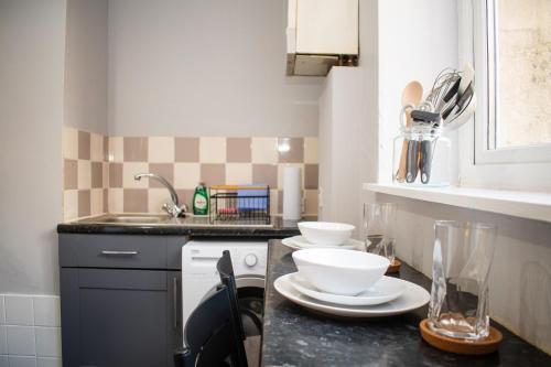 a kitchen with a counter with plates and bowls on it at Stylish 1 Bedroom Flat Newcastle in Old Walker