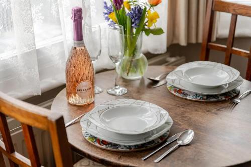a table with two plates and a bottle of wine at Deco Studio: King bed, kitchenette, stylish & comfortable in Brighton & Hove