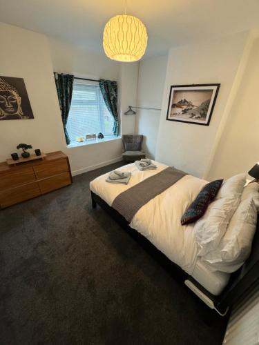 a bedroom with a large bed and a chandelier at 3-Bed House, Birmingham in Birmingham