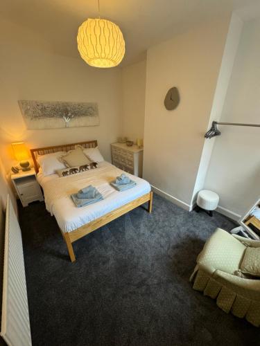 a bedroom with a bed and a chair in it at 3-Bed House, Birmingham in Birmingham