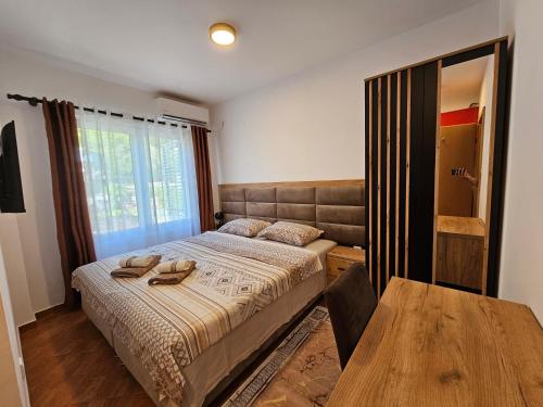 a bedroom with a bed and a table with shoes on it at Dom M Apartments in Budva