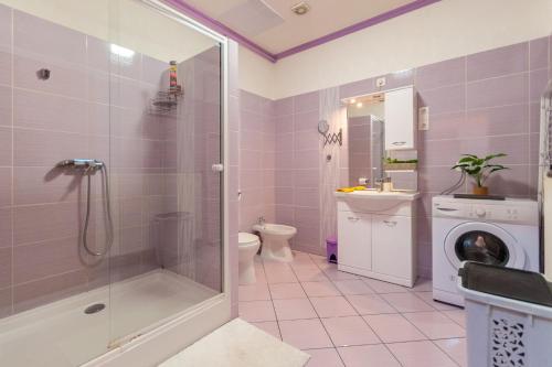 a bathroom with a shower and a washing machine at R APARTMENTS BUDAPEST in Budapest