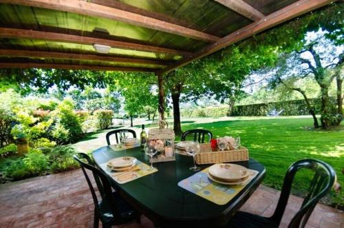 - une table à manger sous une pergola sur une terrasse dans l'établissement Ferienhaus mit Privatpool für 6 Personen ca 120 qm in Montecarlo, Toskana Provinz Pistoia, à Montecarlo