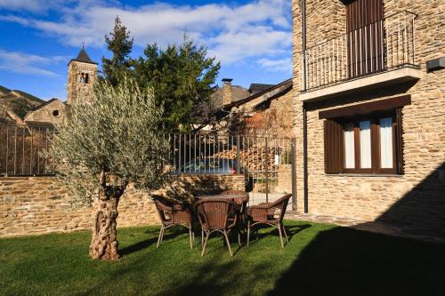 a table and chairs under a tree in a yard at Casa Rural La Comella in Tirvia