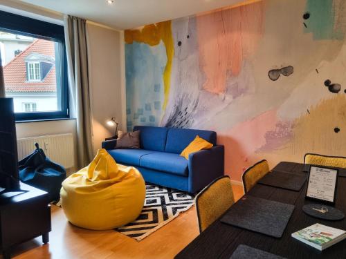 a living room with a blue couch and a table at maremar - City Design Apartment - Luxus Boxspringbetten - Highspeed WIFI - Arbeitsplätze in Braunschweig