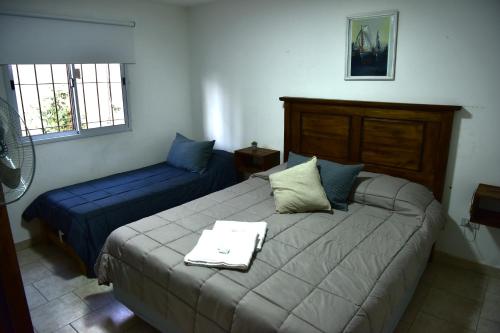 1 Schlafzimmer mit 2 Betten und 2 Fenstern in der Unterkunft Departamentos x dia Viedma CON COCHERA in Viedma