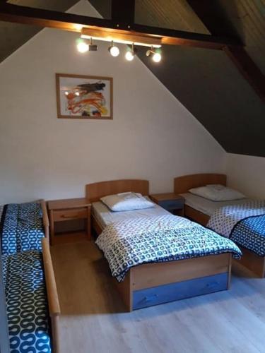 Cette chambre mansardée comprend 3 lits. dans l'établissement Maison Bretonne 8 personnes en Côtes D'Armor, à Gicquel