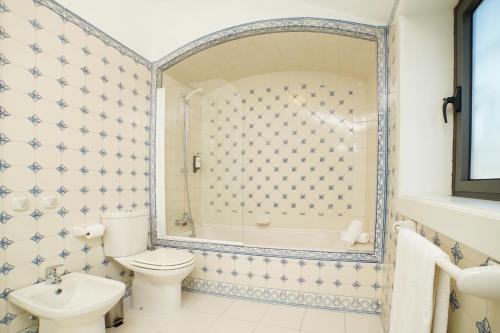 a bathroom with a toilet and a tub and a sink at Solar das Bouças by Quantique in Amares