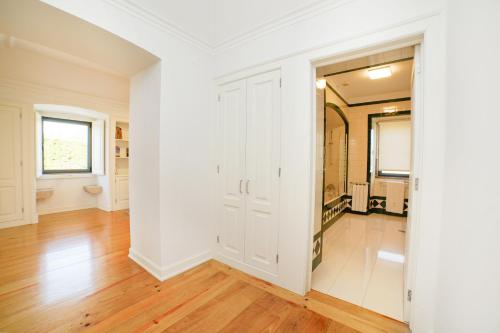 an empty room with white walls and wood floors at Solar das Bouças by Quantique in Amares