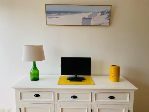 - un bureau avec un ordinateur et une lampe dans l'établissement L'Olliffe Joli Studio Deauville HyperCentre à 2 pas de la Place Morny, à Deauville
