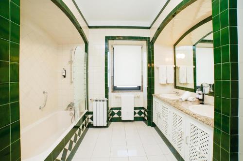 a bathroom with two sinks and a tub and a window at Solar das Bouças by Quantique in Amares