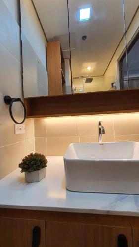 a bathroom with a white sink and a mirror at Luxury Condo with a view of Manila Bay in Manila
