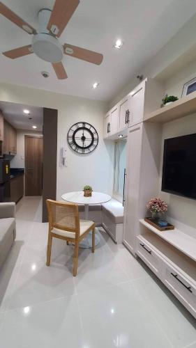 a living room with a table and a clock on the wall at Luxury Condo with a view of Manila Bay in Manila
