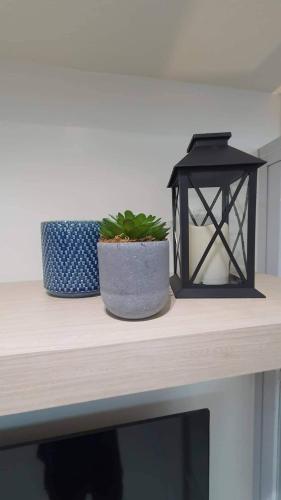 a table with a lantern and a potted plant on it at Luxury Condo with a view of Manila Bay in Manila