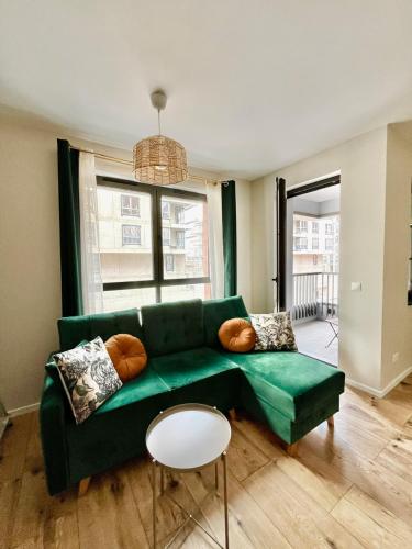 a living room with a green couch and a table at M&M Doki Studio in Gdańsk