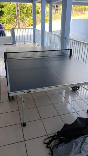 a ping pong table sitting on a porch at Bel appartement de 250 m² dans un coin de paradis in Marigot