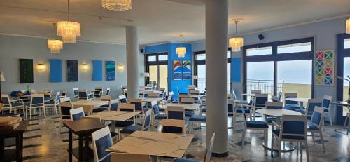 a dining room with tables and chairs and windows at Hotel Cristina in Sorrento