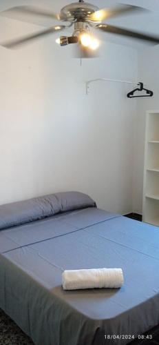 a bed with a white towel on the end of it at Habitaciones y Suite. UPV, UV y Playa in Valencia