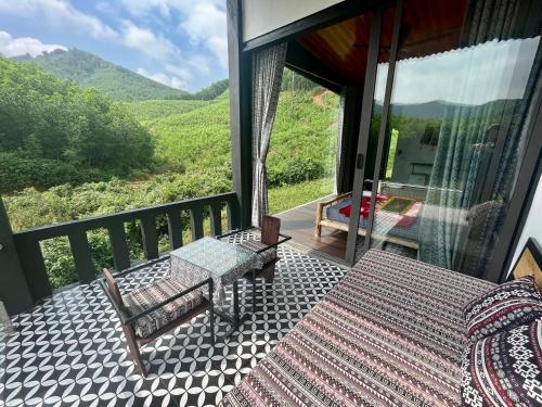 a balcony with a table and a view of a mountain at Nguyen Shack - Phong Nha Resort in Phong Nha