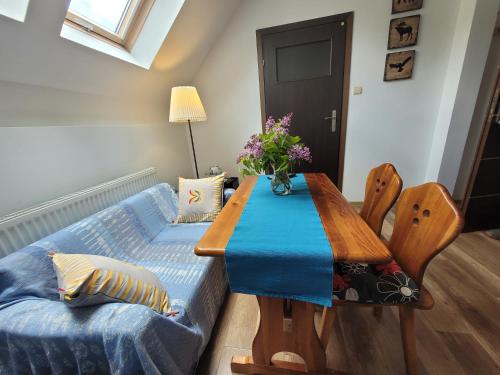 a dining room with a table and a couch at Oberża Pod Kudłatym Aniołem in Cisna