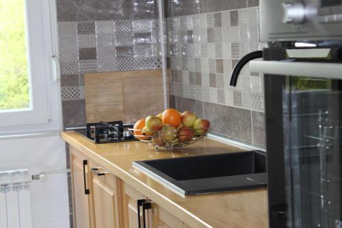 a bowl of fruit on a counter in a kitchen at Apartman Black River in Plitvička Jezera