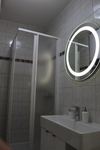 a bathroom with a sink and a shower with a mirror at Apartman Black River in Plitvička Jezera