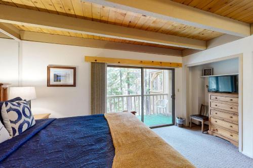 Schlafzimmer mit einem Bett und einer Glasschiebetür in der Unterkunft Creekside at Kingswood in Kings Beach