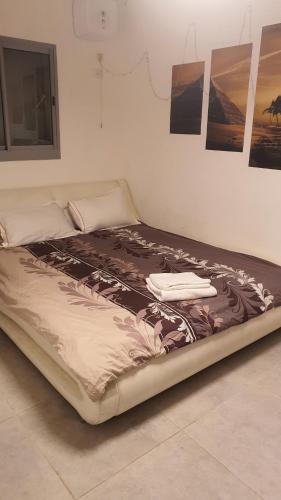 a large bed in a room with pictures on the wall at Dream house in Eilat