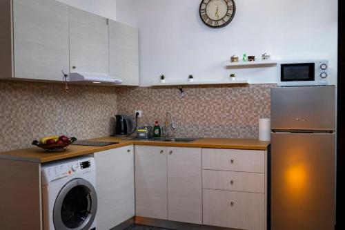 uma cozinha com uma máquina de lavar roupa, um lavatório e uma máquina de lavar louça em LoftLiving 2 by ΑΤΤΙΚΟ ΝΟΣΟΚΟΜΕΙΟ em Atenas