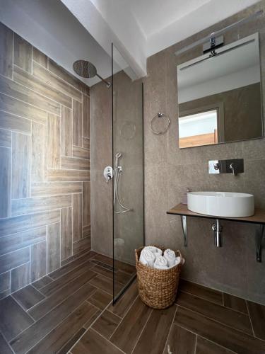 een badkamer met een douche, een wastafel en een spiegel bij Pantheon in Skiathos-stad