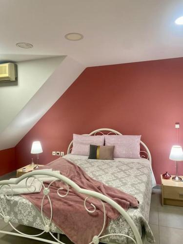a bedroom with a bed with a red wall at Cozy apartment near to the airport in Kouvarás