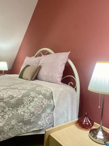 a bedroom with a white bed with pink walls at Cozy apartment near to the airport in Kouvarás