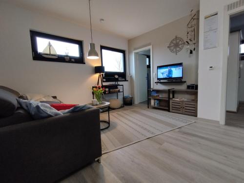 sala de estar con sofá y TV en Ferienwohnung Treibgut en Saal