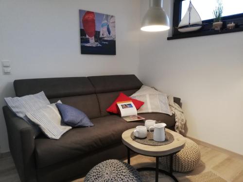 a living room with a brown couch and a table at Ferienwohnung Treibgut in Saal