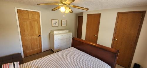 a bedroom with a bed and a ceiling fan at Chandler Hill Base Camp - Enjoy A Nature Getaway in this Rustic Home in the Mountains, 10 minutes from Sunday River Ski Mountain! home in Bethel