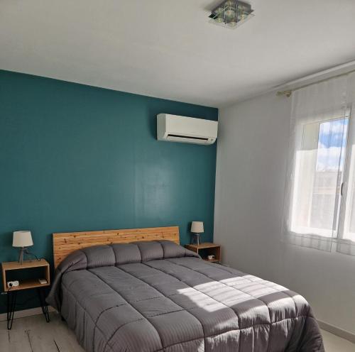 呂內勒的住宿－Chez Valéric，一间卧室设有一张床和蓝色的墙壁