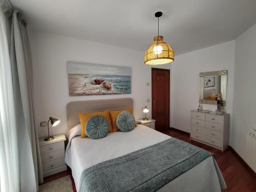 1 dormitorio con 1 cama con almohadas de color naranja y azul en El Pozu las Ranas, en Llanes