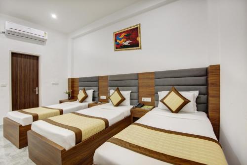 a hotel room with four beds in a room at Hotel SB Grand Inn - Paharganj in New Delhi
