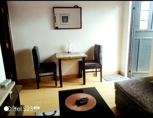 a living room with a table and two chairs at faraja homes in Kakamega