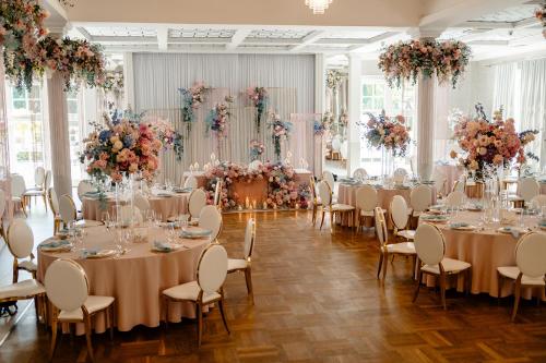 a banquet hall with tables and chairs and flowers at Hotel Toscania in Włoszakowice