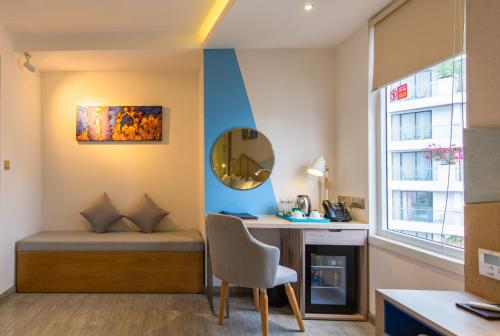 a room with a bed and a desk and a mirror at Le's Cham Hotel in Nha Trang
