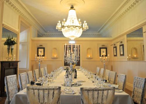 a long table in a room with chairs and a chandelier at Braid Hills Hotel in Edinburgh