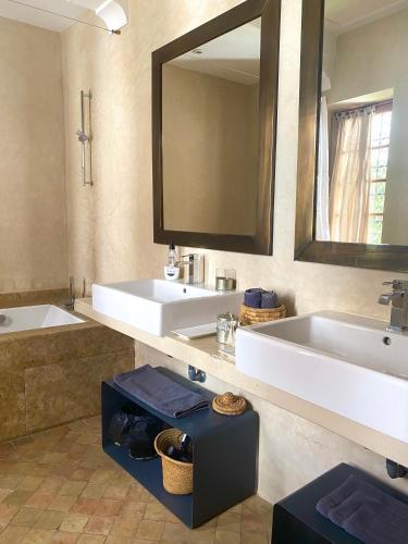 a bathroom with two sinks and a large mirror at Riad Rossi in Marrakesh