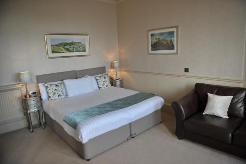 a bedroom with a bed and a leather chair at Braid Hills Hotel in Edinburgh
