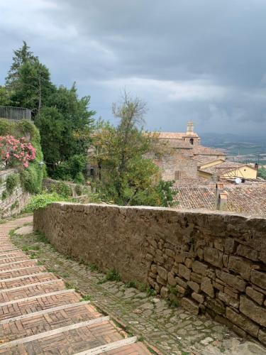 a stone retaining wall next to a stone wall at Dimora Scarnabecco in Todi
