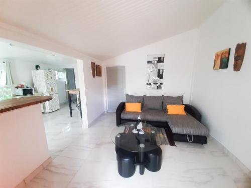 sala de estar con sofá y mesa en Plézi Location F3 au bord de mer, Trois-Ilets en Les Trois-Îlets