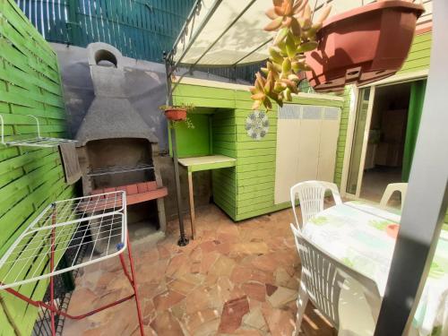 a patio with an outdoor oven and a table and chairs at Plézi Location F3 au bord de mer, Trois-Ilets in Les Trois-Îlets