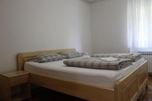 a bed with two pillows on it in a room at Apartman Black River in Plitvička Jezera