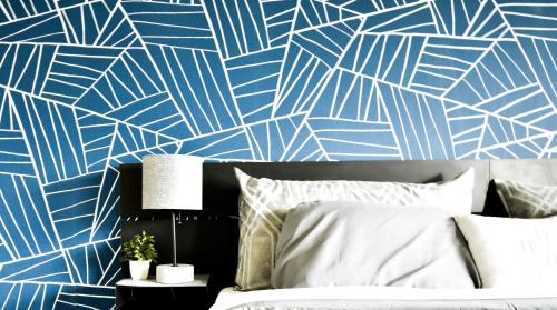 a bedroom with a blue and white patterned wall at Green Harbor Hotel in Marshfield