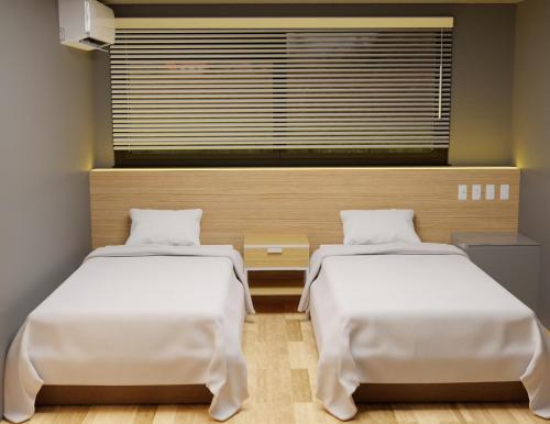 2 Betten in einem Zimmer mit Fenster in der Unterkunft My Home Inn Sennan, Onosato in Ozaki